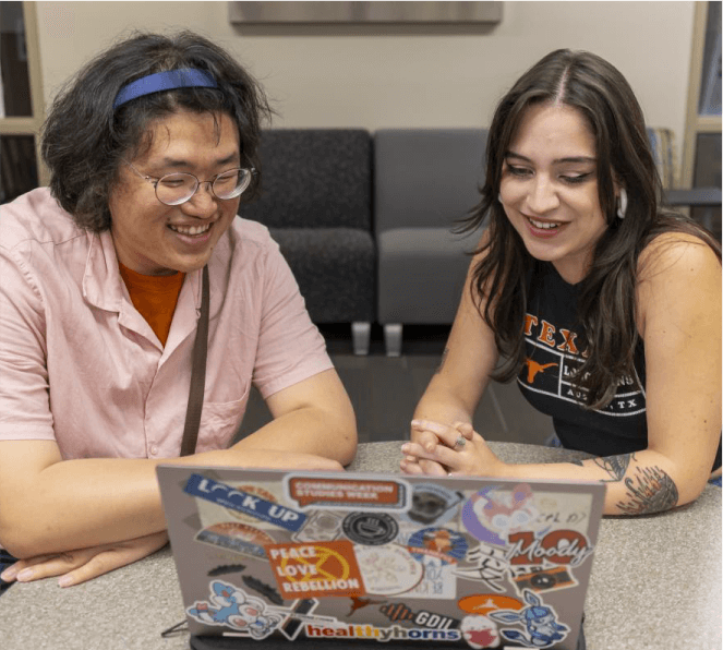 Two students looking at laptop togeter